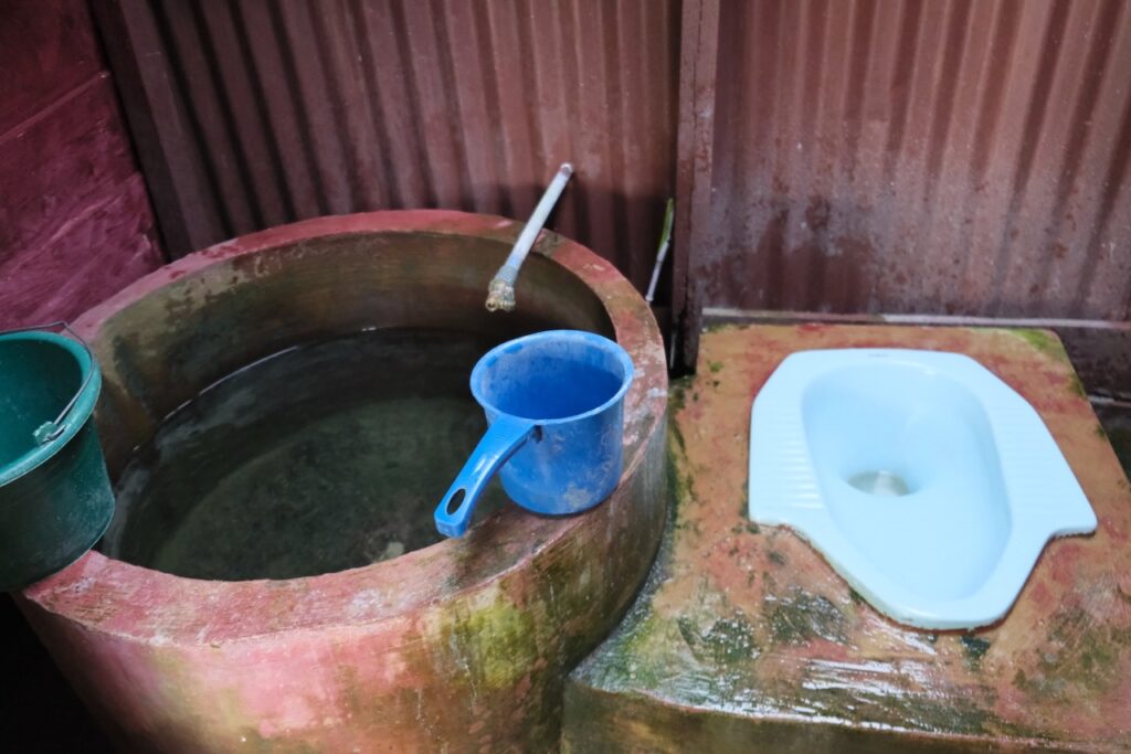 Indonesische Sanitäranlage: Hocktoilette, Spühlung und Dusche